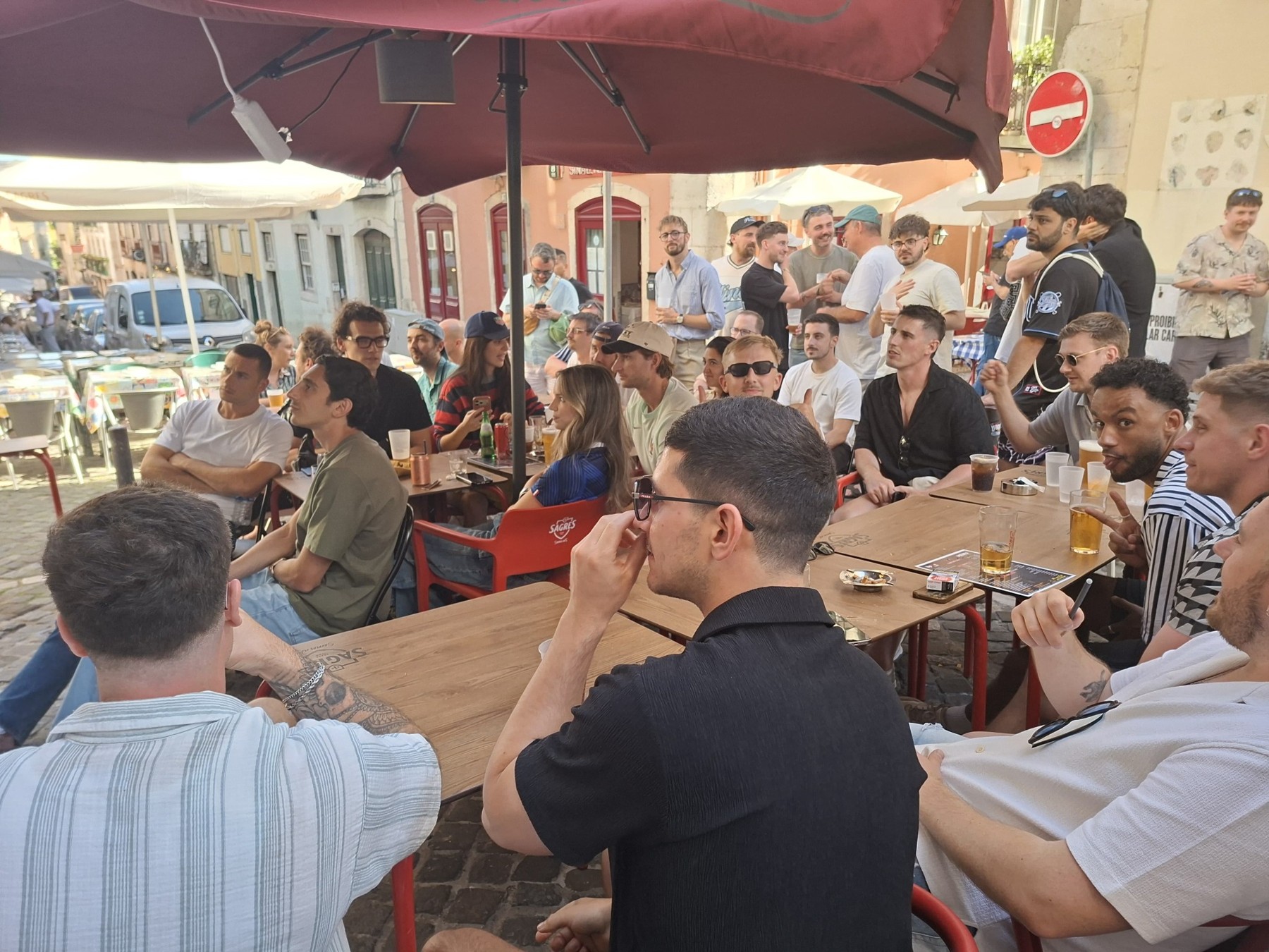 Friends gathered around outdoor tables at The Spot Lisboa